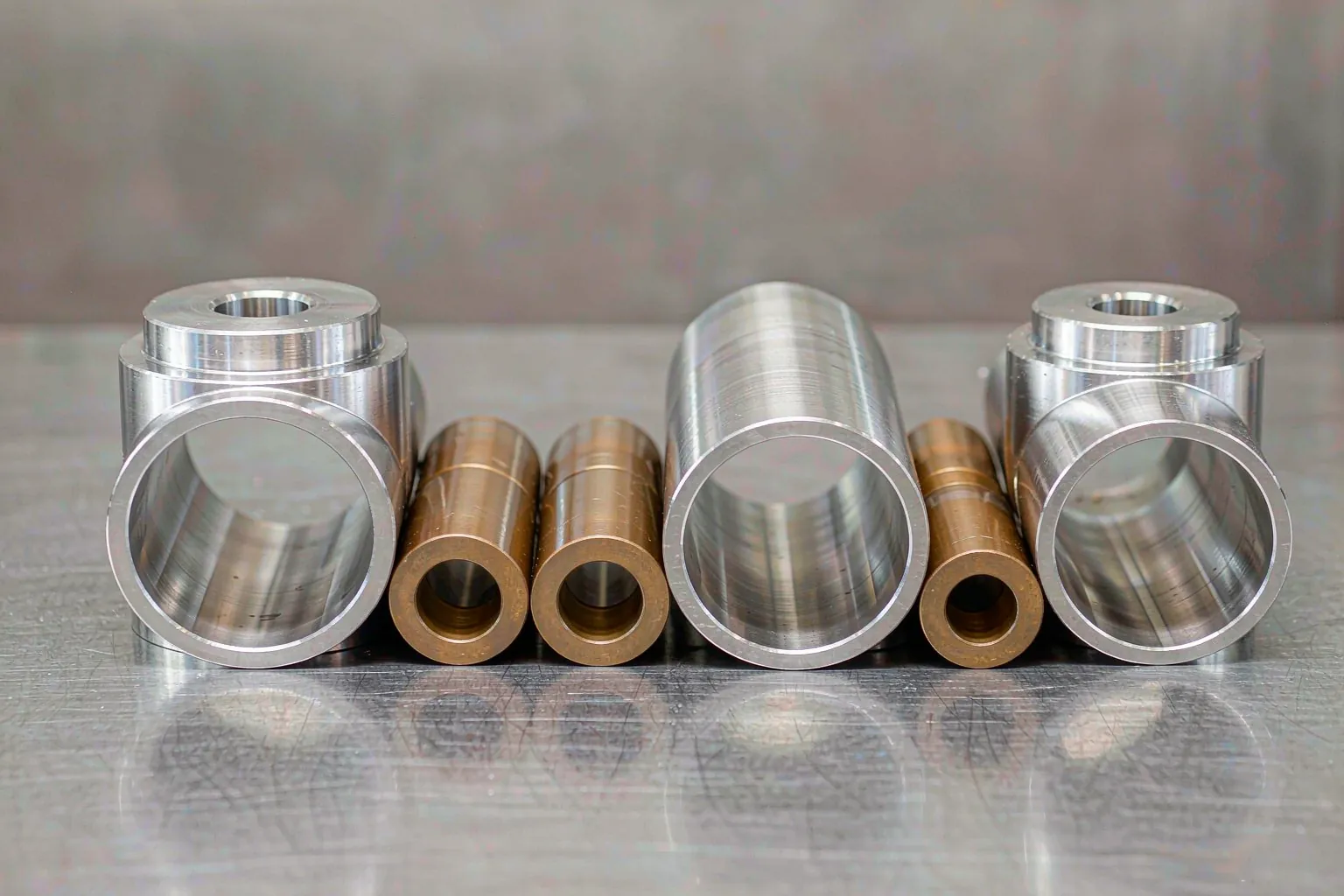 centrifugal casting output of bored cylinder liners and bronze bushings lined up after machining
