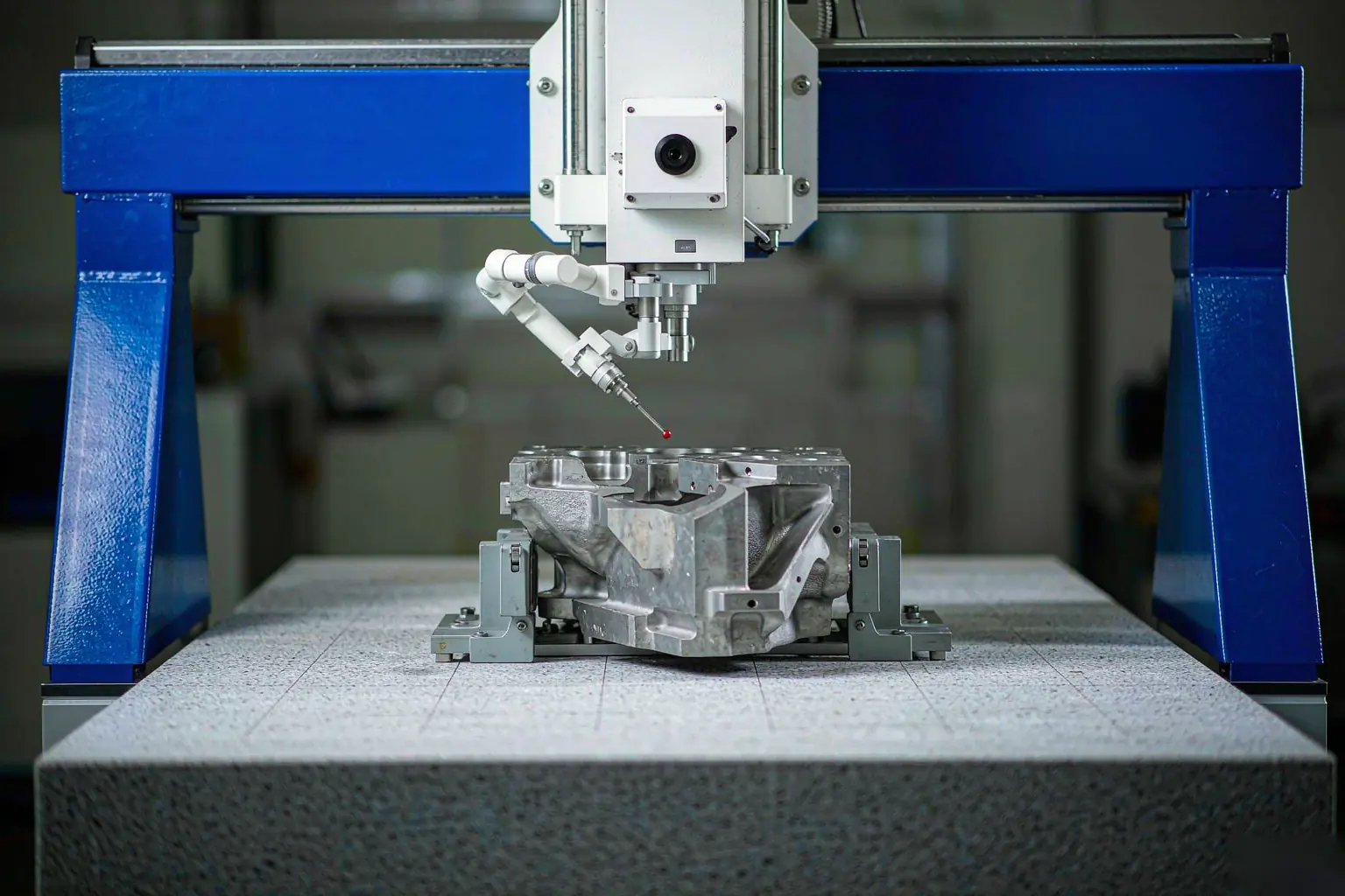 casting first article inspection CMM probe measuring a bore in a cast aluminum housing on a granite surface plate