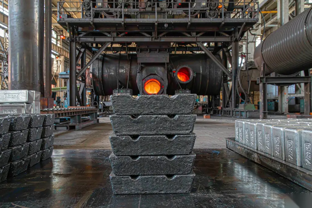 casting price adjustment metal cost drivers stacked pig iron and aluminum ingots beside an induction melting furnace